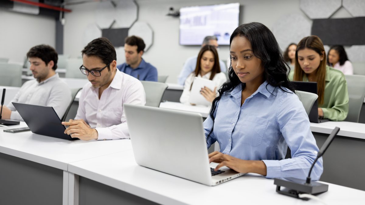 Participantes trabajando con sus laptops durante una sesión de capacitación en la empresa
